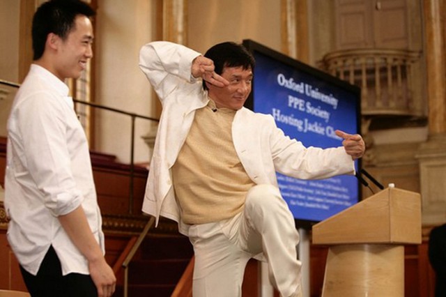 Джеки Чан стоит на сцене в позе кунг-фу рядом с Бо Гуагуа, сыном ныне опального бывшего чиновника компартии Бо Силая, в Оксфордском университете в 2008 году