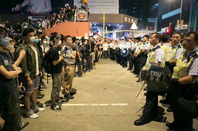 Продемократичні демонстранти перед поліцейськими після усеношних спроб блокувати частини Аргайл-стріт і Нейтан-роуд у районі Монг Кок, Гонконг, 18 жовтня 2014 року