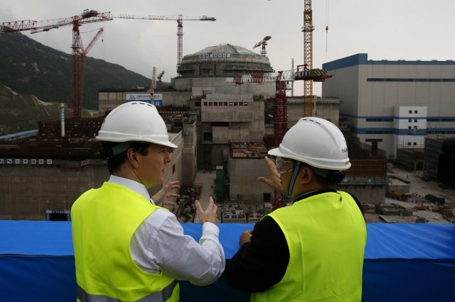 Міністр фінансів Великобританії Джордж Осборн (ліворуч) розмовляє із генеральним менеджером спільного підприємства Taishan Nuclear Power Го Ліміном поруч зі споруджуваним ядерним реактором на атомній електростанції в Тайшані провінції Гуандун, 17 жовтня 2013 року. Компартія Китаю намагається виграти кілька контрактів на будівництво об'єктів атомної енергетики в інших країнах
