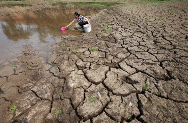 Житель деревни идёт по частично пересохшей реке. Она пересохла из-за засухи в связи с небольшим количеством осадков и высокими температурами, провинция Гуанси Китая, май 2012 г