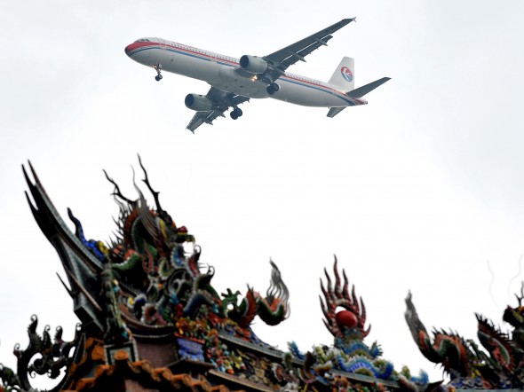 Самолёт авиакомпании China Eastern Airlines пролетает над храмом в Тайпэе, Тайвань. Фото: Patrick Lin/AFP/Getty Images