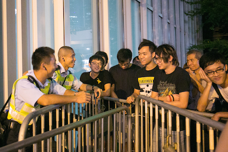 Демонстранты, протестующие в поддержку демократии, мирно общаются с гонконгскими полицейскими в Центральном округе 5 октября 2014 года