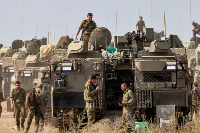 Солдати ізраїльської армії стоять біля своїх бронетранспортерів (БТР) Namer на позиції біля кордону з Газою на півдні Ізраїлю 11 жовтня 2023 року. (Menahem Kahana/AFP via Getty Images)
