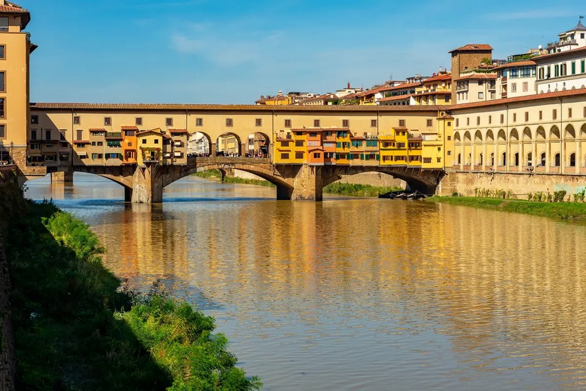 Понте Веккйо (Старий міст) перетинає річку Арно у Флоренції, Італія. Він складається з трьох сегментних арок із закритими спандрелами, які являють собою два трикутники, що утворюють верхню частину кожної арки. Найбільша, середня арка має ширину близько 98 футів, а бічні арки мають ширину близько 89 футів. Коридор Вазарі (R) простягається від Палаццо Веккйо (ратуші) через галерею Уффіці, через Понте Веккйо до Палаццо Пітті. (Mistervlad/Shutterstock)