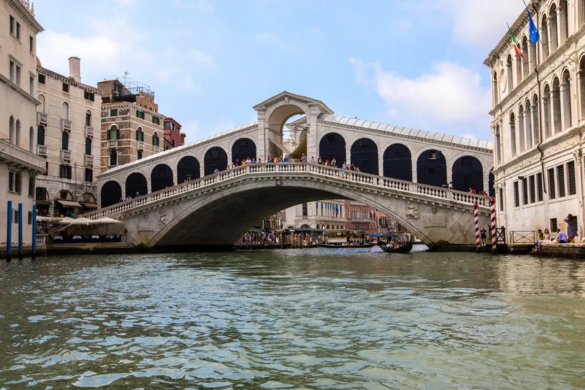 Міст Ріальто перетинає Гранд-канал у Венеції, Італія. Шість тисяч дерев'яних стовпів підтримують мармуровий і істрійський кам'яний арочний міст, створений з клиноподібних, звужених каменів, які називаються «voussoirs». Вони були покладені перпендикулярно до арочного тиску. Кожна сторона аркадного пішохідного мосту має ширину 66 футів і довжину 83 фути і веде до прямокутної палуби. (chrisdorney/Shutterstock)