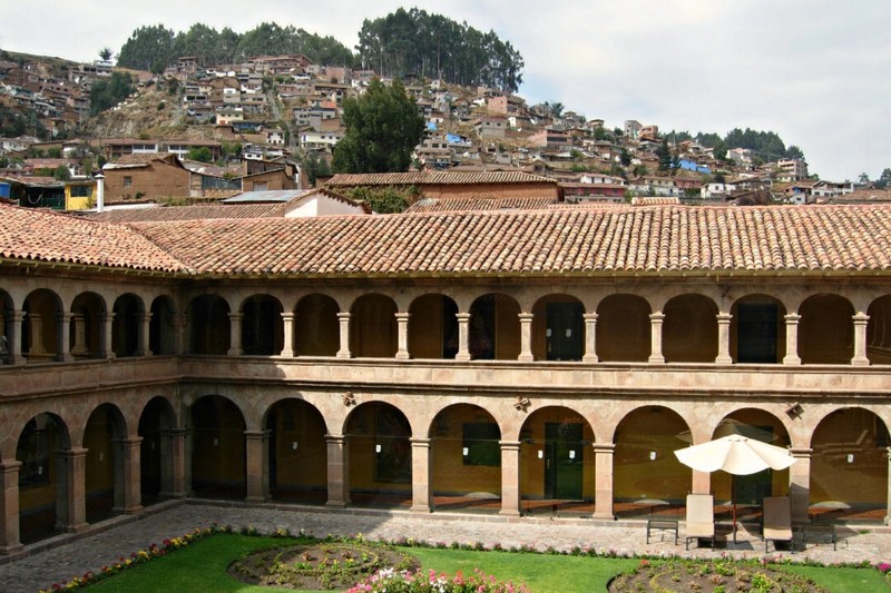 Кам'яна будівля готелю Belmond Hotel Monasterio поєднується з побіленими та гладко обробленими фасадами. Серед кам'яних доріжок внутрішнього дворика розташовані квітники та рослини в горщиках. З внутрішнього дворика відкривається вид на навколишні двоповерхові аркади з незліченними класичними арками, що плавно розташовані на вершинах кам'яних іонічних колон. (Eleni Mavrandoni/Shutterstock)