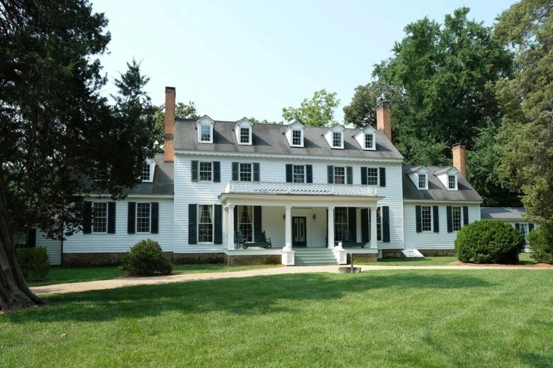 25 акров Шервудского леса, открытых для посещения, окружены зрелыми деревьями, ухоженными самшитами и газонами. Вход в дом является частью круговой подъездной дороги. Хотя мансардные окна и окна второго этажа не симметричны с фасадной стороны дома из-за различных достроек и реконструкции, портик в стиле греческого возрождения над входной дверью отвлекает внимание от неравномерности. (Sherwood Forest Plantation Foundation)