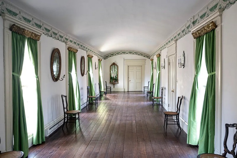 Довгий 68-футовий бальний зал Шервудського лісу має соснові підлоги, на яких проводилися танці. Повторювана облямівка шпалер, що зображує ламбрекен, прикріплений до оздобленої карнизи, прикрашає кімнату. До облямівки пасують яскраво-зелені шовкові штори, схожі на оригінальні, що висять на позолочених металевих карнизах. Деякі антикварні дзеркала оснащені свічниками; світло свічки відбивалося в дзеркалі, щоб краще освітлювати кімнату. (Sherwood Forest Plantation Foundation)