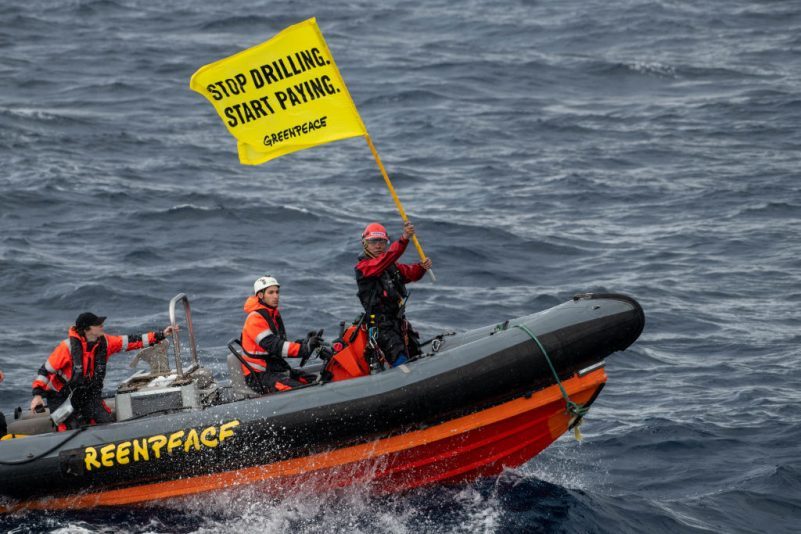  Філіппінський активіст Greenpeace Йеб Сано розмахує прапором на узбережжі після спроби піднятися на борт нафтової платформи Shell, що перевозиться судном White Marlin, 31 січня 2023 року в Атлантичному океані, на північ від Гран-Канарії, Іспанія. (Handout/Getty Images)