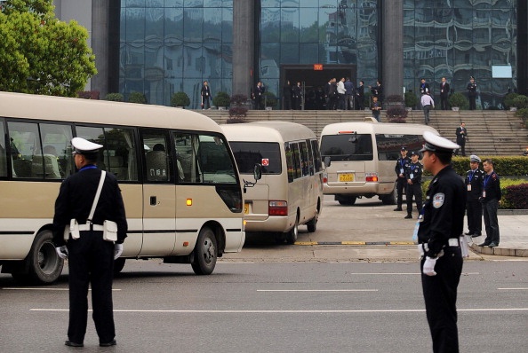 Автобусы подъезжают к зданию суда, где проходит заседание по делу Лю Ханя и его сообщников. Фото: STR/AFP/Getty Images