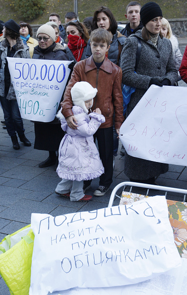 Украинцы, которые были вынуждены покинуть свои дома из-за военного конфликта на востоке страны, держат плакаты во время акции протеста у здания Кабинета Министров в Киеве 19 октября 2014 года. Фото: Vladimir Shtanko/Anadolu Agency/Getty Images