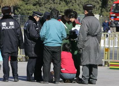 Пекінські поліцейські заарештовують апелянтку. Фото: AFP