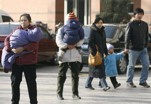 Жінки несуть тепло вдягнених дітей у холодну погоду в Пекіні. (Фредерік Дж. Браун / AFP/Getty Images)