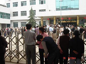 16 мая в городе Лунхуэй провинции Хунань состоялся суд по делу Ян Сяоцина. Сотни жителей города Лунхуэй стоят вне здания в поддержку Яна. Милиция отбирала камеры, но благодаря множеству людей, фотографии этого события смогли появиться. Фото: Великая Эпоха