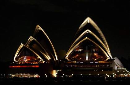 Оперний театр у Сіднеї залитий світлом 31 березня 2007 р. напередодні «Години Землі». Все місто, а також і компанії, урядові відділи, окремі особи й сім'ї, закликає на годину вимкнути світло. Фото: Ian Waldie /Getty Images