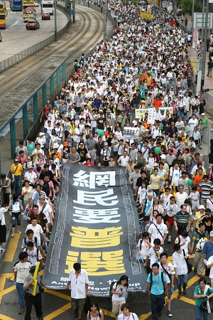 1 июля 2006 года десятки тысяч граждан приняли участие в продемократическом марше в Гонконге. На большом плакате, который держат участники марша, написано: 'Пользователи Интернета хотят всеобщего избирательного права'. Фото: Великая Эпоха