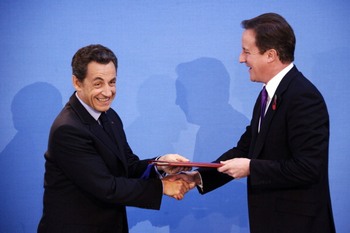 Президент Франции Николя Саркози (слева) и премьер-министр Великобритании Дэвид Кэмерон обмениваются копиями документов после подписания договора во время англо-французской встречи на высшем уровне в Ланкастер-Хаус 2 ноября в Лондоне, Англия. Фото:Lionel