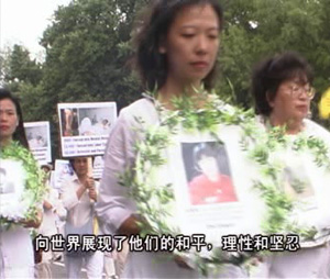Послідовники Фалуньгун (школа духовного і фізичного самовдосконалення) тримають фото загиблих від репресій.