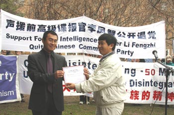 Руководитель Всемирного Центра помощи выхода из компартии, доктор наук Гао Давэй (справа) вручает Ли Фэнчжи документ центра, подтверждающий его выход из рядов КПК. Фото: Си Мин/The Epoch Times