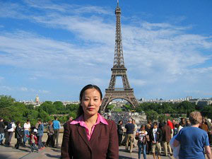 Пані Чень Ін, колишня дружина співробітника китайського посольства в Парижі, перед Ейфелевою Вежею. Фото: Велика Епоха