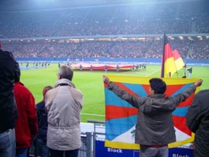 Три тибетских национальных флага и плакаты поменьше с надписями «Свободный Тибет» по приказу Пекина были запрещены на стадионе в Гамбурге. Фото: Free Tibet