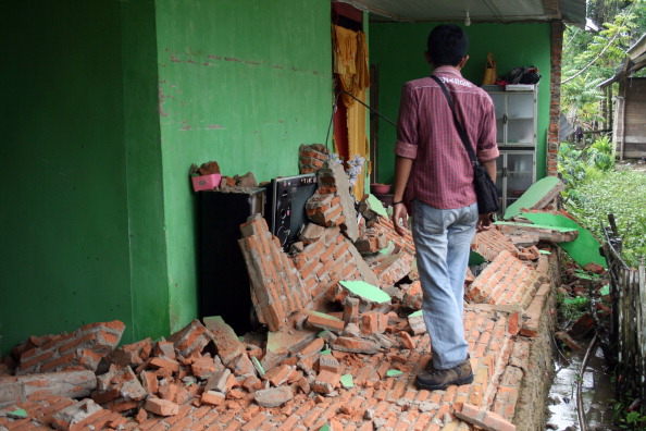 Индонезиец осматривает повреждения дома в результате 6,2-бального землетрясения в Кендари. Бедствие произошло ранее, 25 апреля 2011 года, на индонезийском острове Сулавеси. Фото: STR /Getty Images
