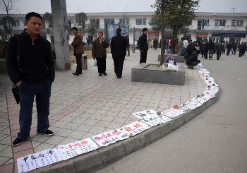 В г.Ченду провинции Сычуань на тротуаре разложены объявления о поиске работы. Фото: Getty Images