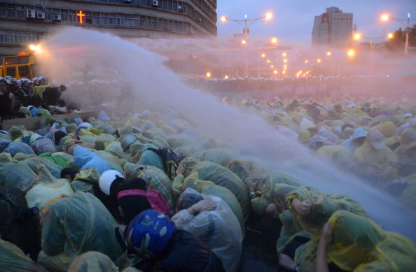 Поліція застосовує водомети для розгону мітингувальників під час анти-ядерної демонстрації біля залізничного вокзалу в Тайбеї 28 квітня 2014 р. Фото: SAM YEH/AFP/Getty Images