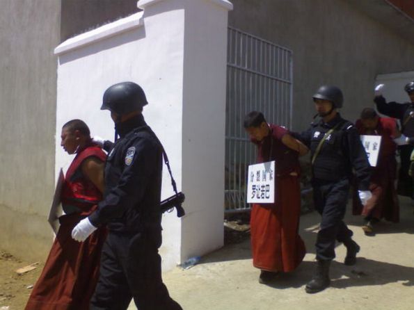 Китайские спецслужбы забирают тибетских монахов в место заключения. Фото: Китайский военный форум