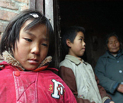 Дев'ятирічна китайська дівчинка-сирота Цзюань-Цзюань - одна з небагатьох, хто не заразився СНІДом, плаче, розповідаючи про страждання її батьків перед смертю в них дома у селі Лісінь рік тому. Фото: AFP /Getty Images