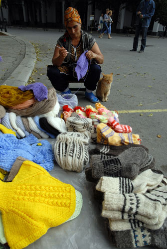 Теплые вещи для озябших туристов, женщина вяжет прямо на улице. Фото: Владимир Бородин/Великая Эпоха.