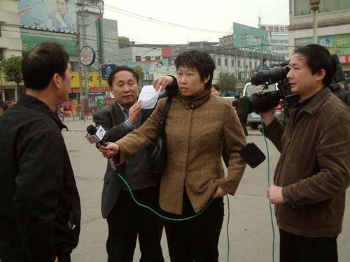 Ось так в Китаї беруть інтерв'ю. Людині, у якої беруть інтерв'ю заздалегідь на папері пишуть «правильні» відповіді на питання кореспондента, після чого вона читає їх перед камерою. Фото з secretchina.com
