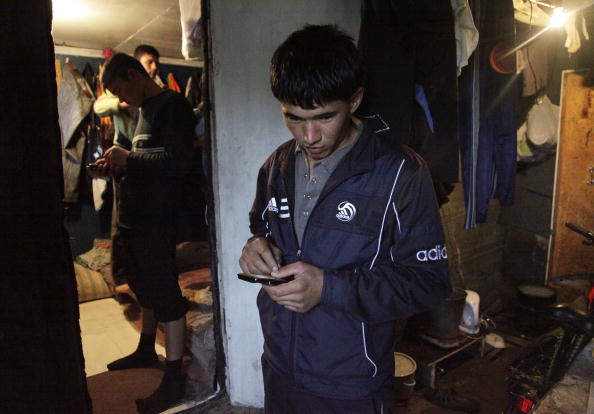 Таджицькі трудові мігранти відправляють повідомлення зі своїх мобільних телефонів у Москві. Фото: OXANA ONIPKO/AFP/Getty Images