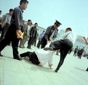 Полицейские избивают последователя Фалуньгун на площади Тяньаньмэнь в Пекине в то время, когда он хотел выразить свой протест против репрессий Фалуньгун коммунистическим правительством. Фото с epochtimes.com
