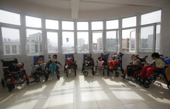 Дети, больные церебральным параличом, ожидают добавки после обеда в центре для сирот и детей-калек города Синин. 24 февраля 2009 года, Китай, провинция Цинхай. Фото: China Photos/Getty Images