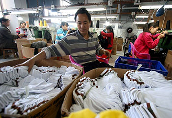 Робітники на швейній фабриці з виробництва шкарпеток в м. Цзіньцзян, південно-східна китайська провінція Фуцзянь, 9 травня. Швейна промисловість Китаю сильно постраждала від спаду у світовій економіці. Фото: STR/AFP/Getty Images