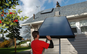 Человек устанавливает солнечные батареи на крыше своего дома. После того, как на этой неделе будет раскрыта технология «микрогенерации», каждый дом в Великобритании сможет стать мини-электростанцией. Фото: Melanie Conner/Getty Images