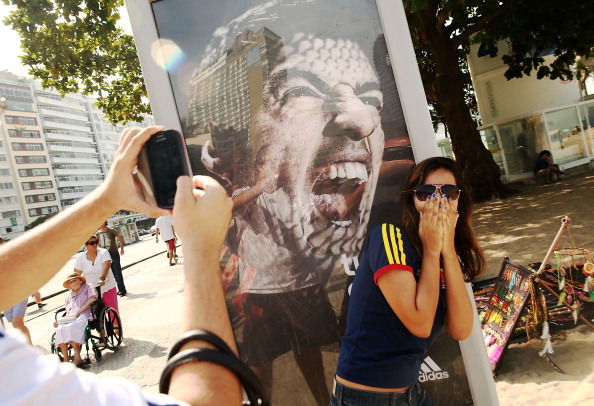Дівчина фотографується біля білборду з Луїсом Суаресом, жартуючи з приводу інциденту, в якому уругваєць вкусив свого суперника Джорджо К'єлліні. Фото: Mario Tama/Getty Images