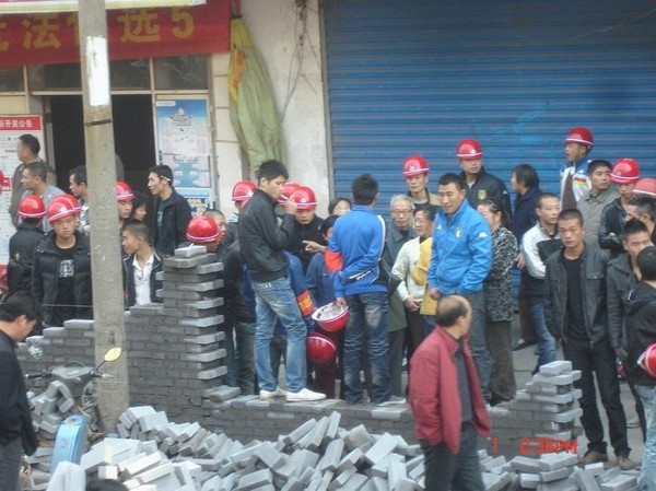 Среди рабочих компании-застройщика находятся неизвестные люди, предположительно члены местных банд, которые власти использовали для нападения на протестующих жильцов. Город Цзинчжоу провинции Хэбэй. Октябрь 2010 год. Фото с epochtimes.com