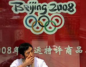 30 апреля 2007 года. Мужчина курит на фоне рекламы Олимпийских игр-2008 в центре Пекина. По данным Международной Амнистии, Олимпийские игры будущего года используются в качестве катализатора репрессий в Китае. Фото: The Epoch Times