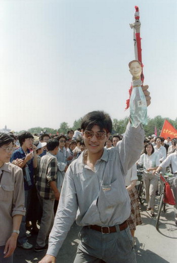 Фото: В период восстания студентов, молодой человек держит в руке бутылку, над которой расположен портрет Дэн Сяопина. По-китайски «сяопин» - фамилия партийного лидера, звучит так же, как и «сяопин» - «маленькая бутылка». Пекинская площадь Тяньаньмэнь. 25