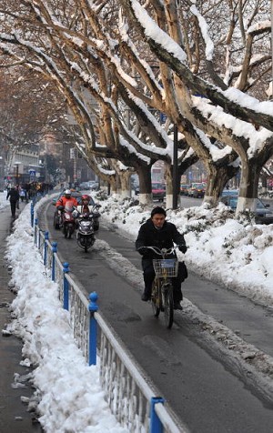 Жители восточно-китайского города Наньцзин путешествуют по заснеженным и заледенелым дорогам. Во время самой холодной зимы за прошедшее столетие в Китае миллионы людей страдали от метелей, которые вызвали транспортный затор, перебои в электроснабжении и т
