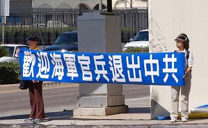 Добровольцы из Международного центра помощи по выходу из КПК держат плакат с надписью: «Мы приветствуем офицеров и солдат, вышедших из КПК». Фото: Великая Эпоха