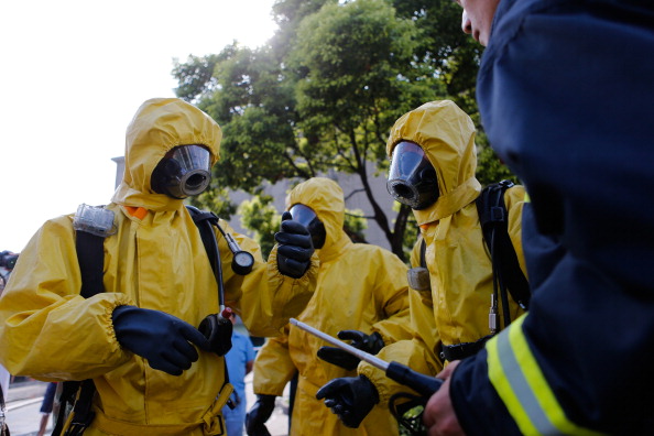 Пожежники в захисних костюмах зібралися біля місця витоку аміаку на холодильному складі харчової компанії в районі Баошань у Шанхаї, де 31 серпня 2013 року загинули 15 осіб, десятки захворіли. Фото: AFP/AFP/Getty Images