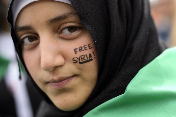 Женщина, участвующая в акциях протеста против сирийского режима. Фото: FABRICE COFFRINI/AFP/GettyImages