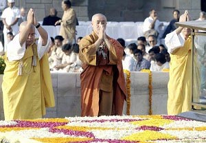 Буддийские монахи молятся перед монументом Отца Индии Махатма Ганди в Нью-Дели. Фото: Raveendran/AFP/Getty Images