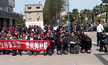Півгодини сотні китайських вчителів на колінах марно прочекали зустрічі з чиновниками. Фото надали учасники акції 