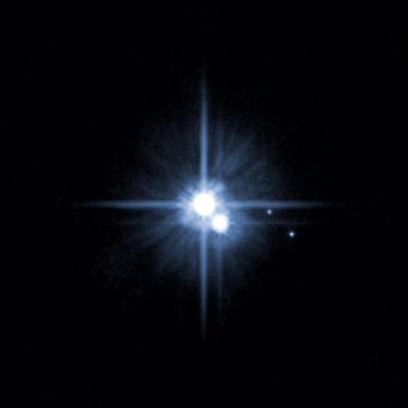 Плутон в оточенні супутників. Фото: NASA/ Getty Images