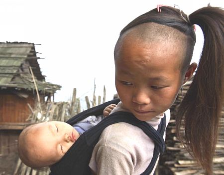 Дівчинка несе маленького брата. Фото: Getty Images