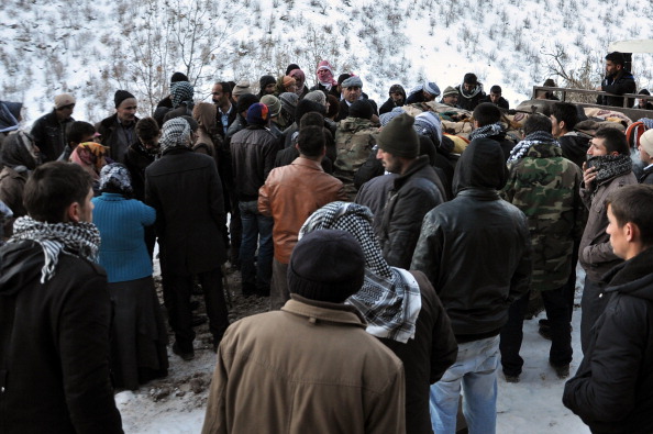 Місцеві жителі села Ортасу зібралися біля машини, яка вивозить тіла загиблих у результаті обстрілу турецькою авіацією. Фото: ENN/AFP/Getty Images